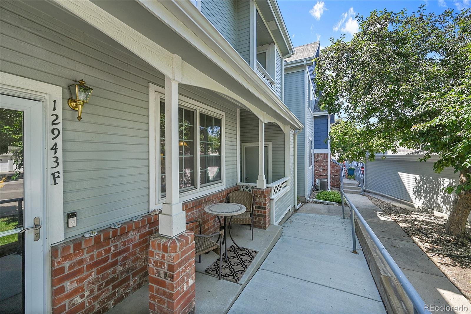 Image 1: Ramp to front door, sitting area, and enclosed porch with unit