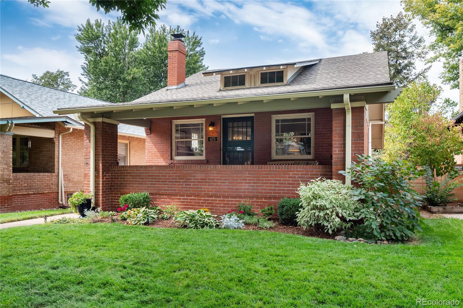 Image 1: Picture perfect setting with large, covered front porch and a stunning garden on a classic tree-lined street.