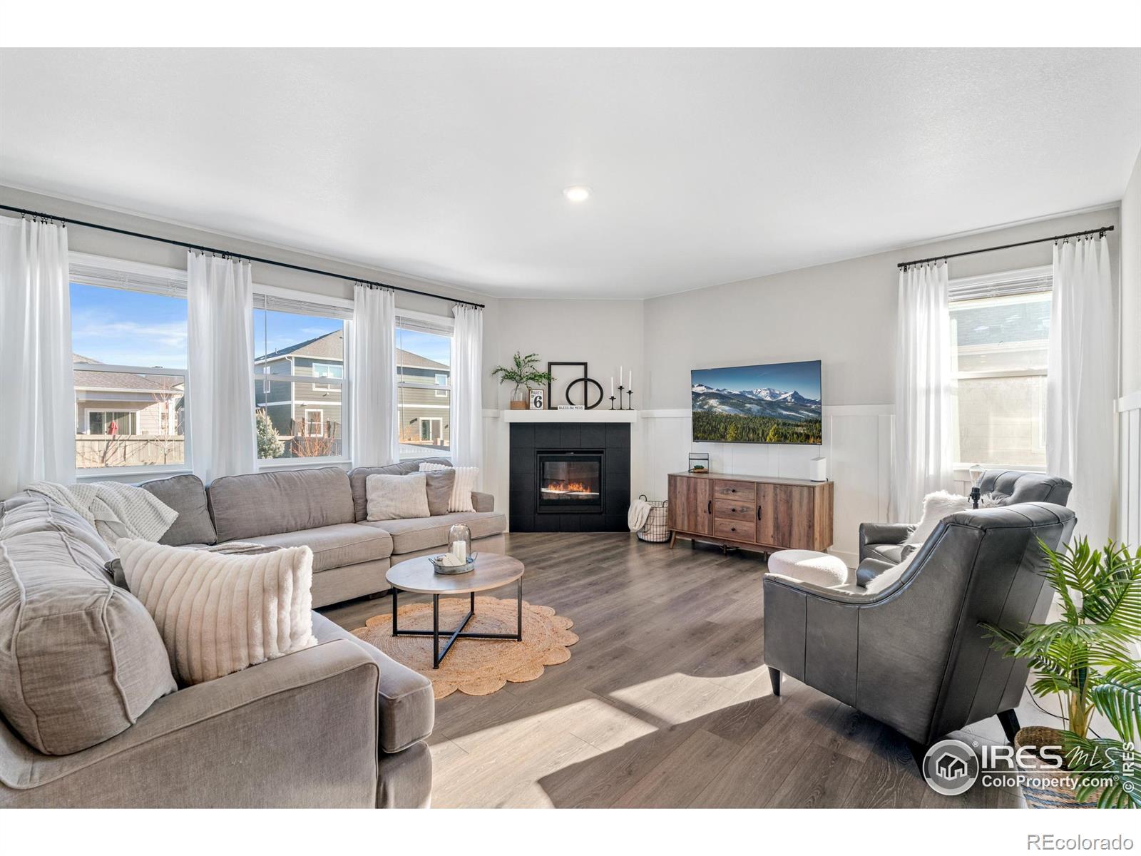 Image 4: The living room is bright and airy and features a gas fireplace.
