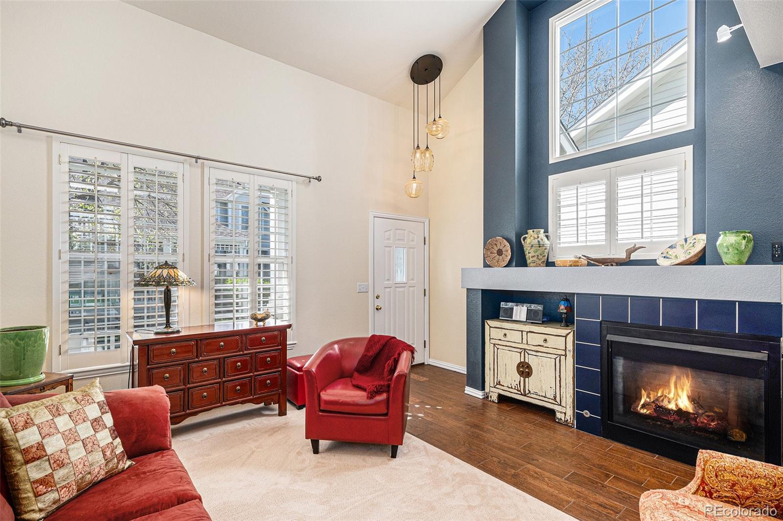 Image 1: Living room with large windows and gas fireplace. Notice the dramatic entryway light fixture.