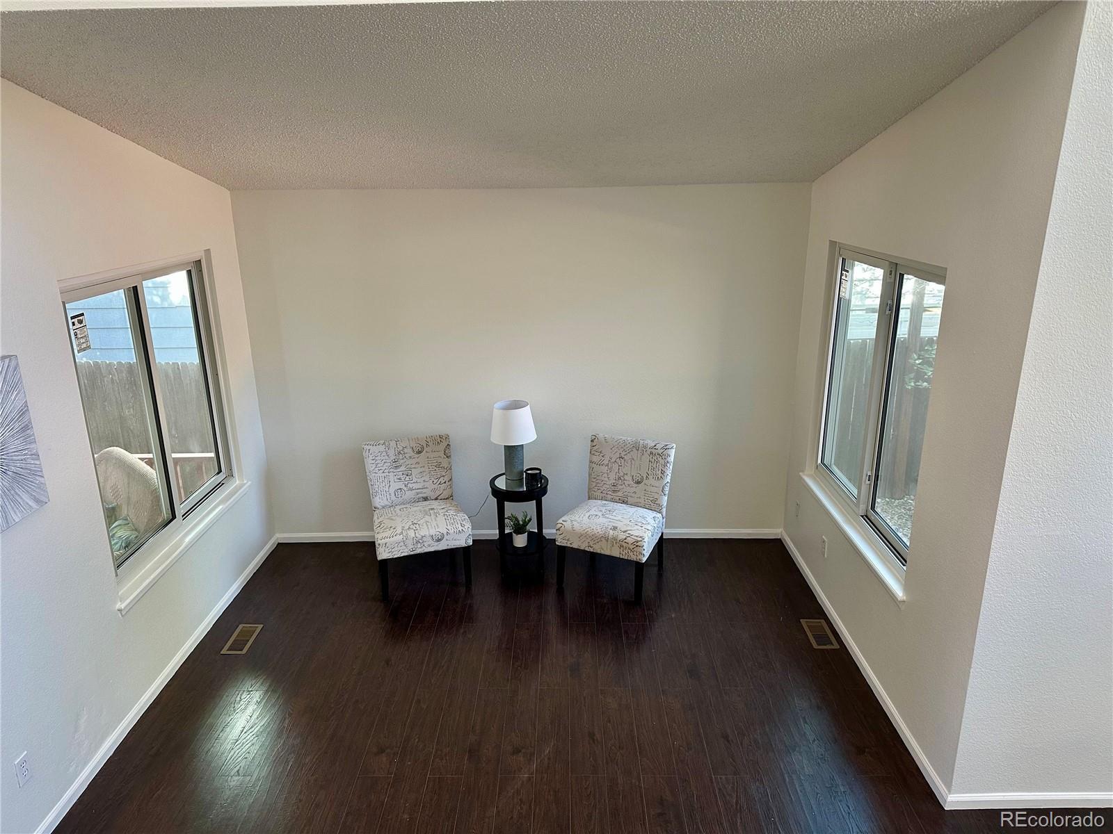 Image 3: Front room with freshly painted baseboard and windowsill. Look how simple it was to update the room by painting the oak.