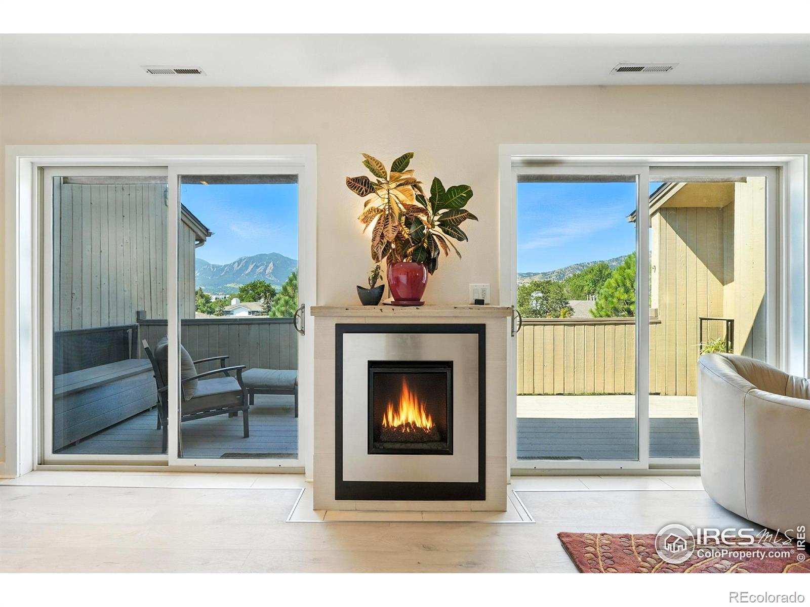 Image 2: Two large sliding doors in the great room with a cozy fireplace between them.