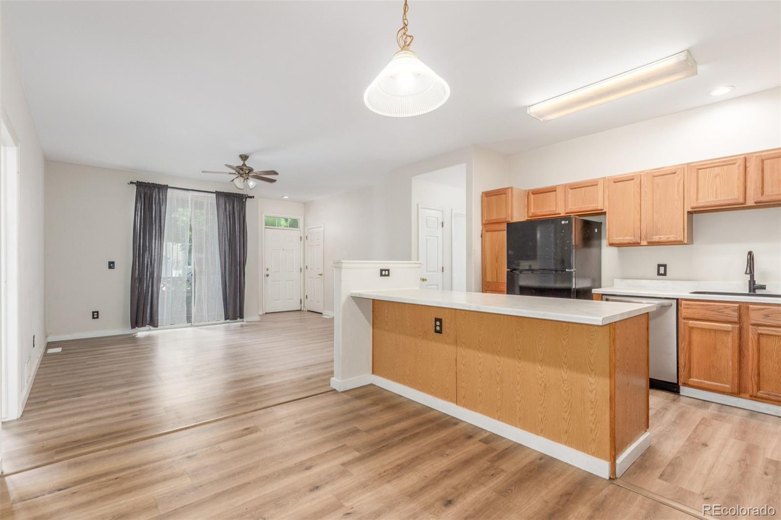 Image 4: Open concept combines dining area, kitchen, and living room with access to private front porch.