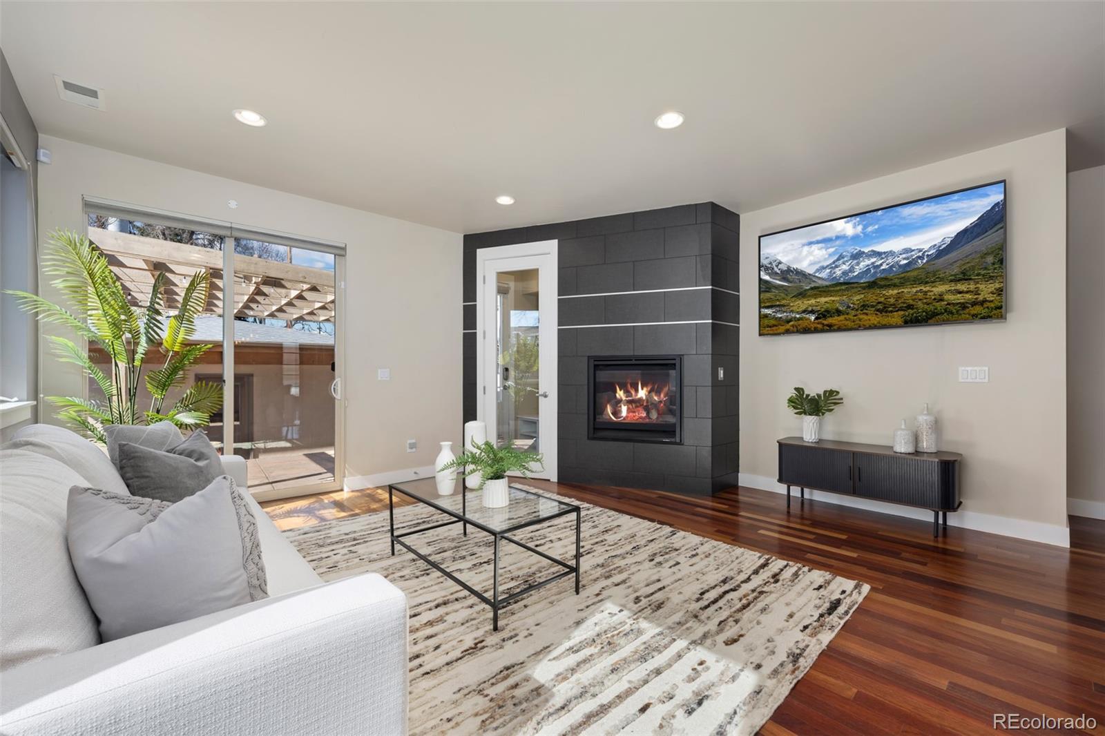 Image 4: The main floor living room features a fireplace, patio and mudroom access