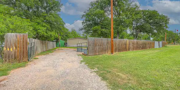 Image 2: Gated entrance to the fully fenced property