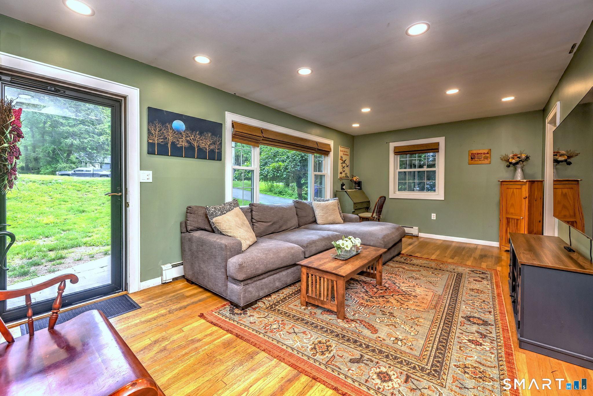 Image 3: Enter through the front door into the sun-filled living room, with recessed lights and hardwood flooring.