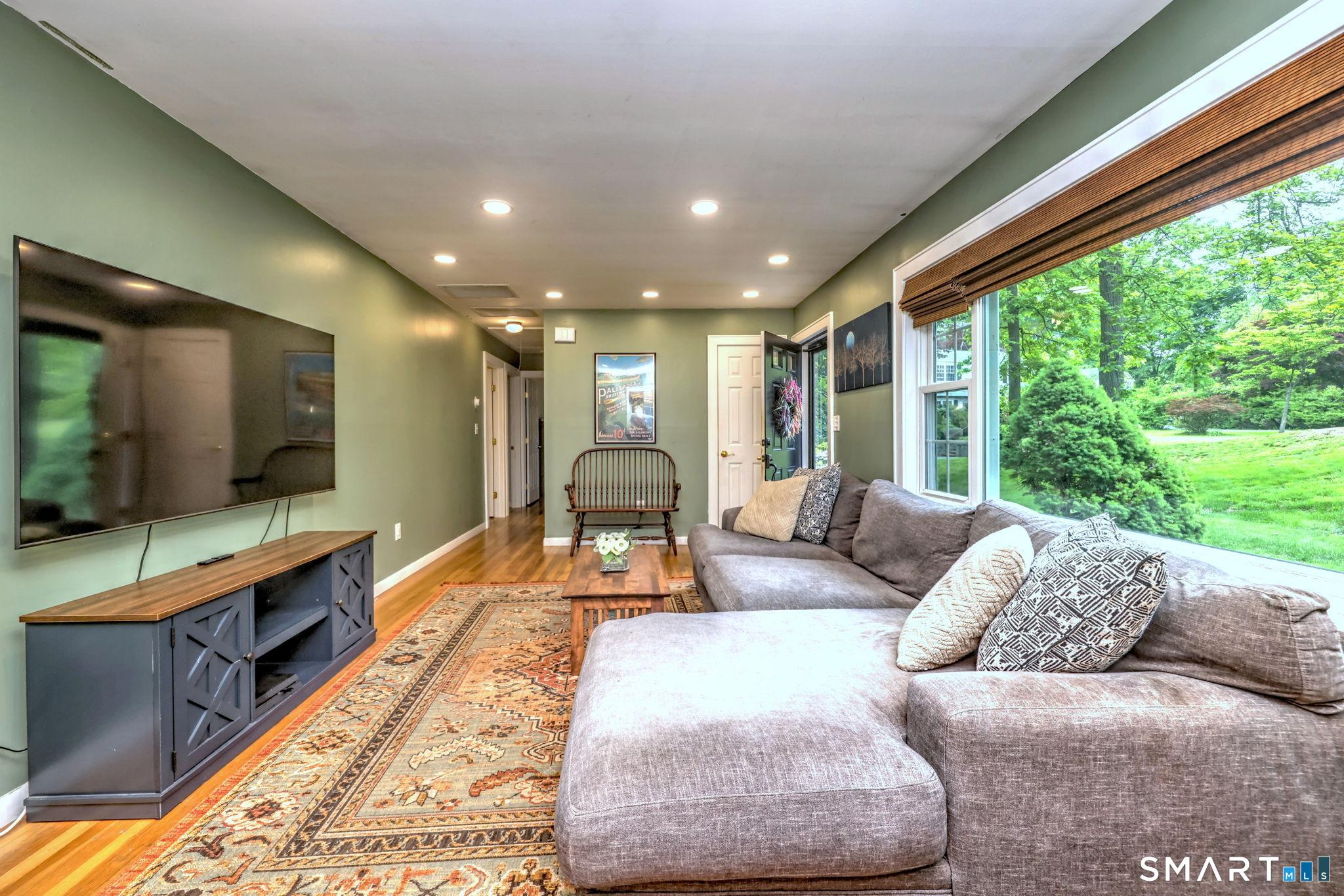 Image 4: Spacious living room opens to the eat-in kitchen, and also to a hallway with three comfortable bedrooms and full bath.