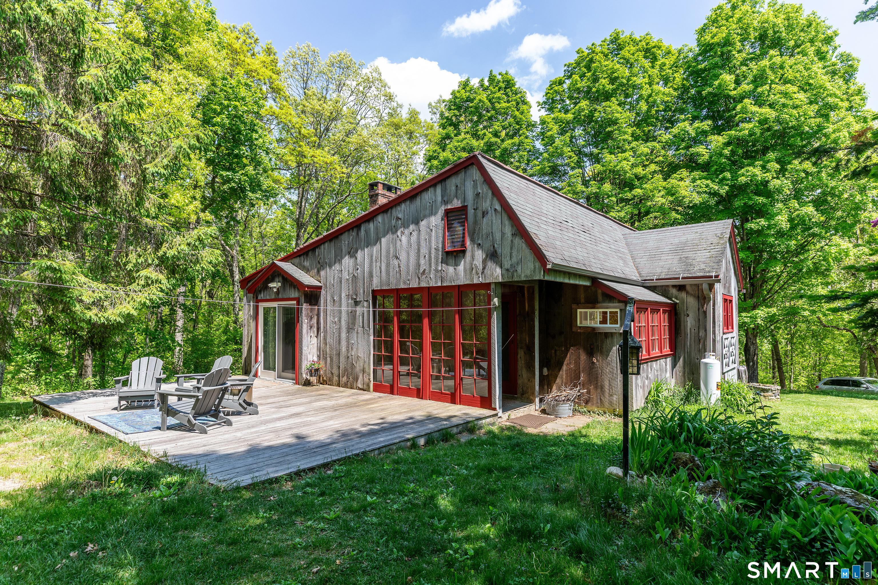Image 2Back of House: Just behind the glass windows at the back of the house sits an additional open mudroom. Featuring a durable slate floor, it is the perfect, highly functional space for storing your firewood right where you need it