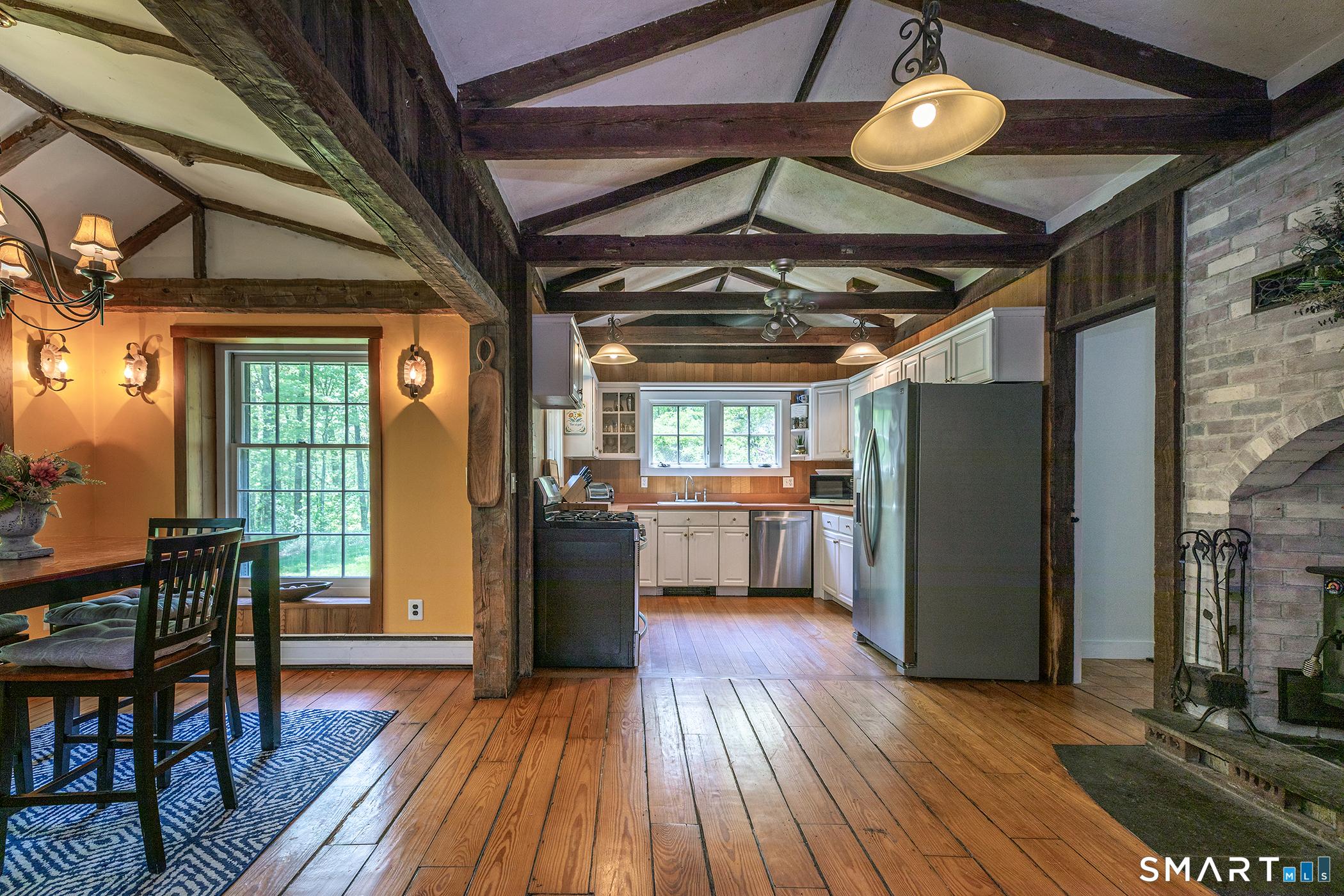 Image 4Other: This open-concept space blends the family room, kitchen, & dining area under cathedral ceilings & rustic exposed beams. Perfectly airy and inviting for gatherings or cozy nights.
