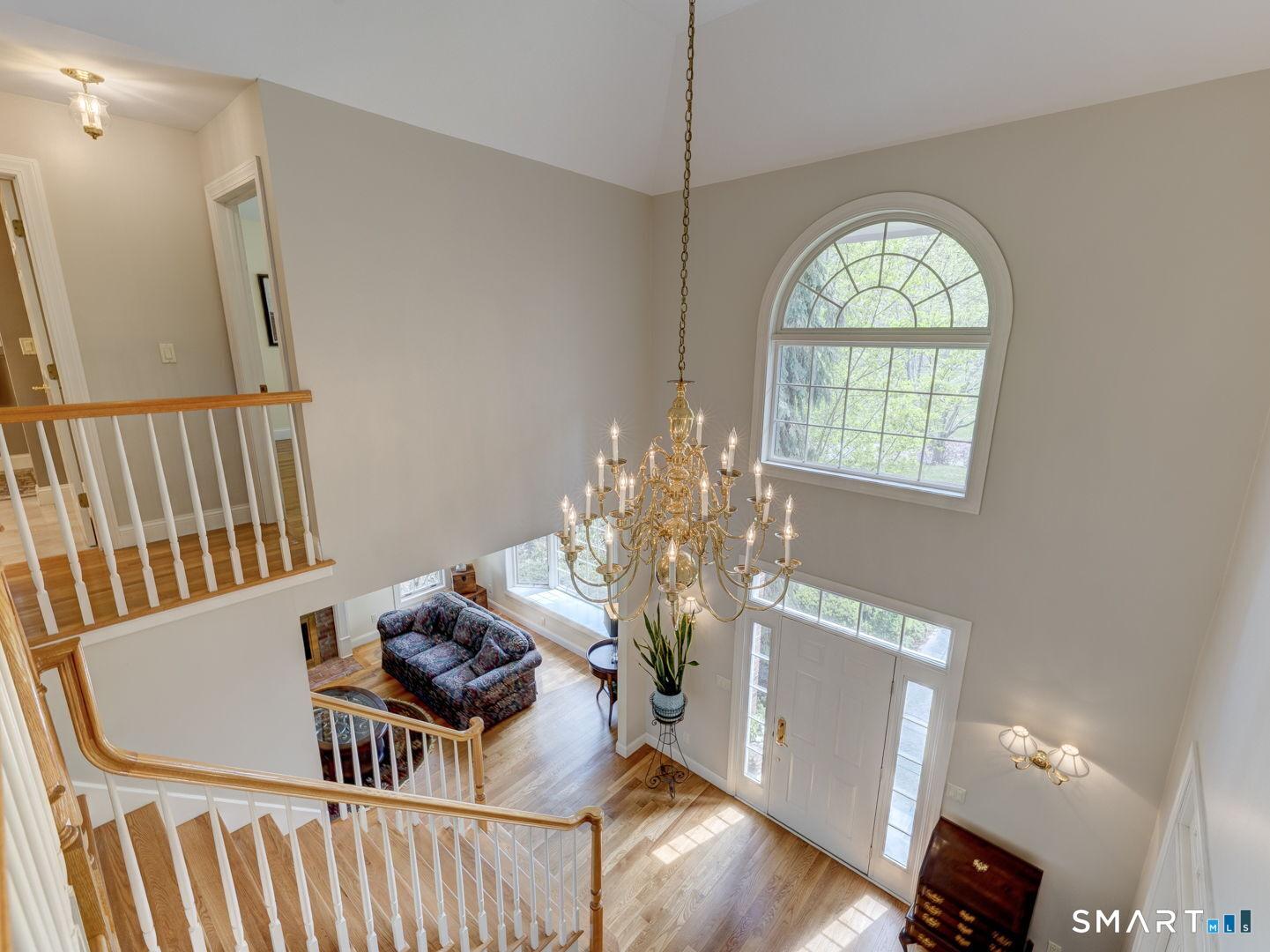 Image 3: Elegant chandelier, soaring ceiling, and palladium accent window welcome all upon entry.