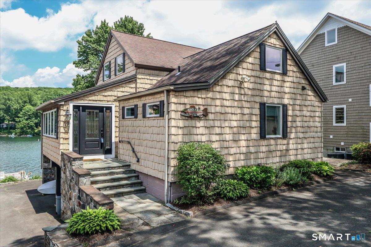 Image 3Front of House: Vinyl Shake siding. Easy access from Driveways to the house and to the water