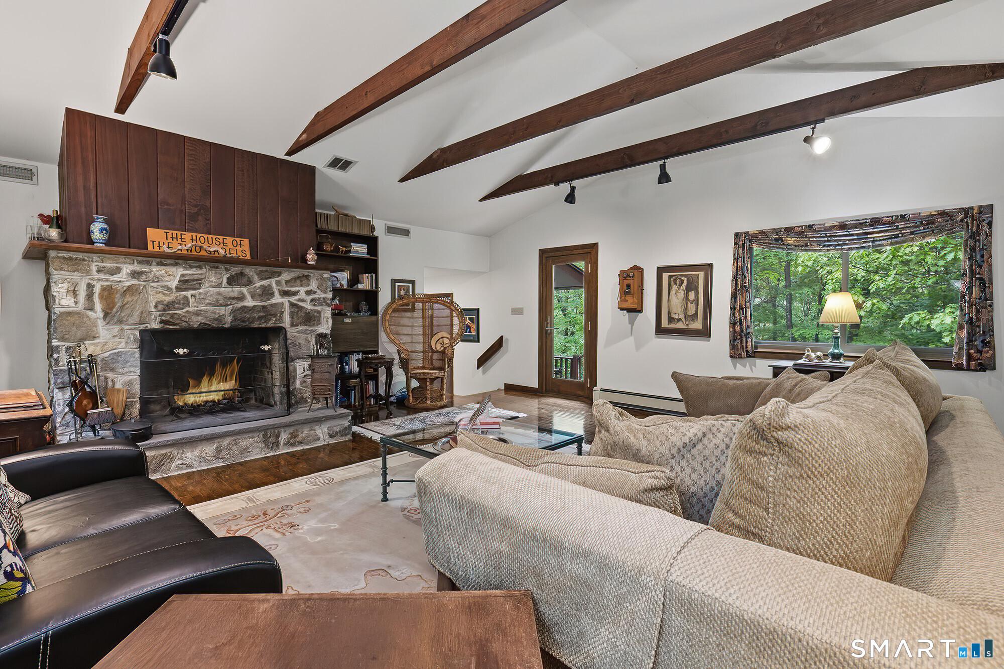 Image 2: Beautiful large living room with stone fireplace and door out to deck
