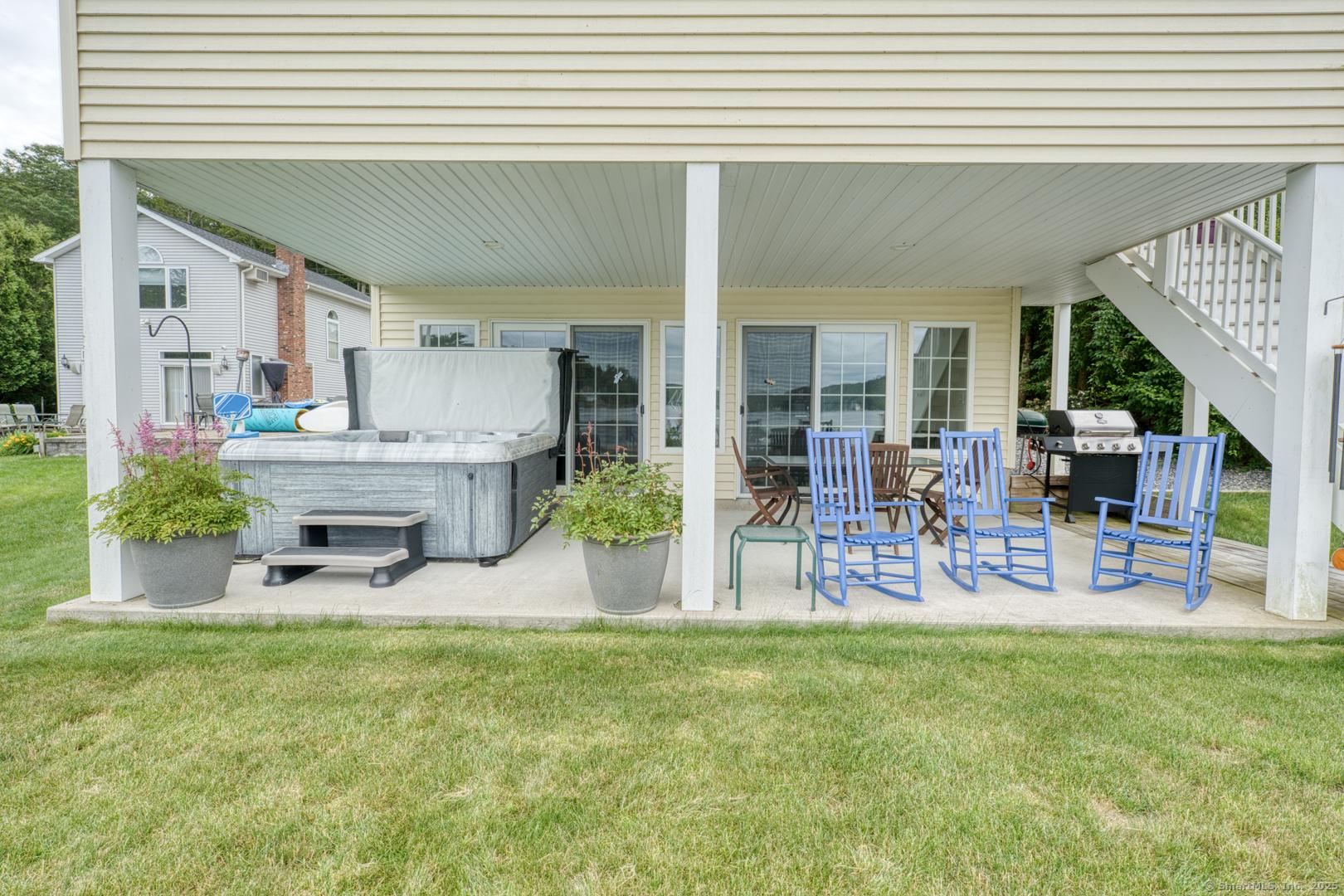 Image 3: Lower patio with hot tub and entrance into home.