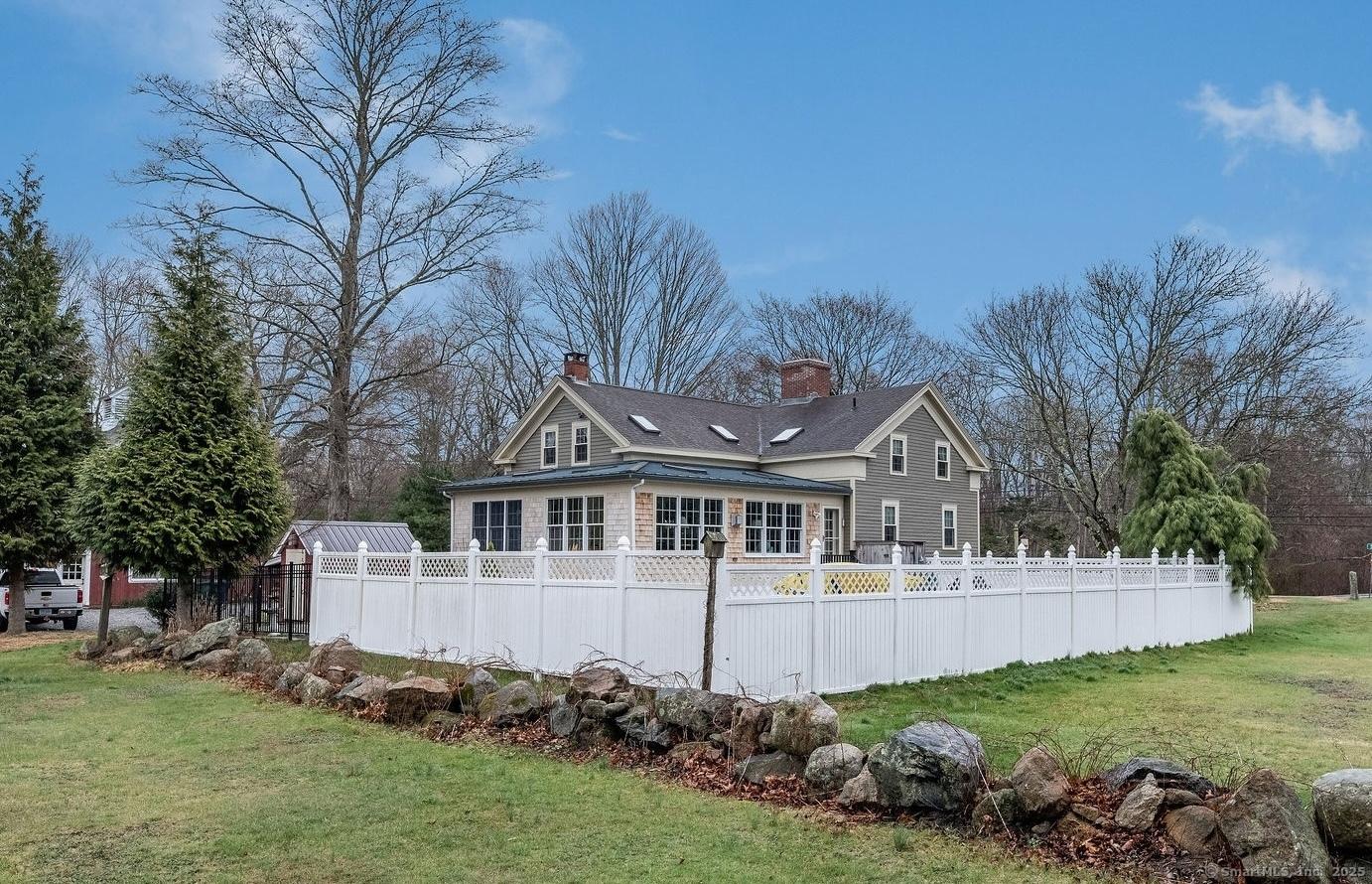 Image 4: privacy fence surrounds the salt water pool, outdoor shower, fire pit, and putting green.
