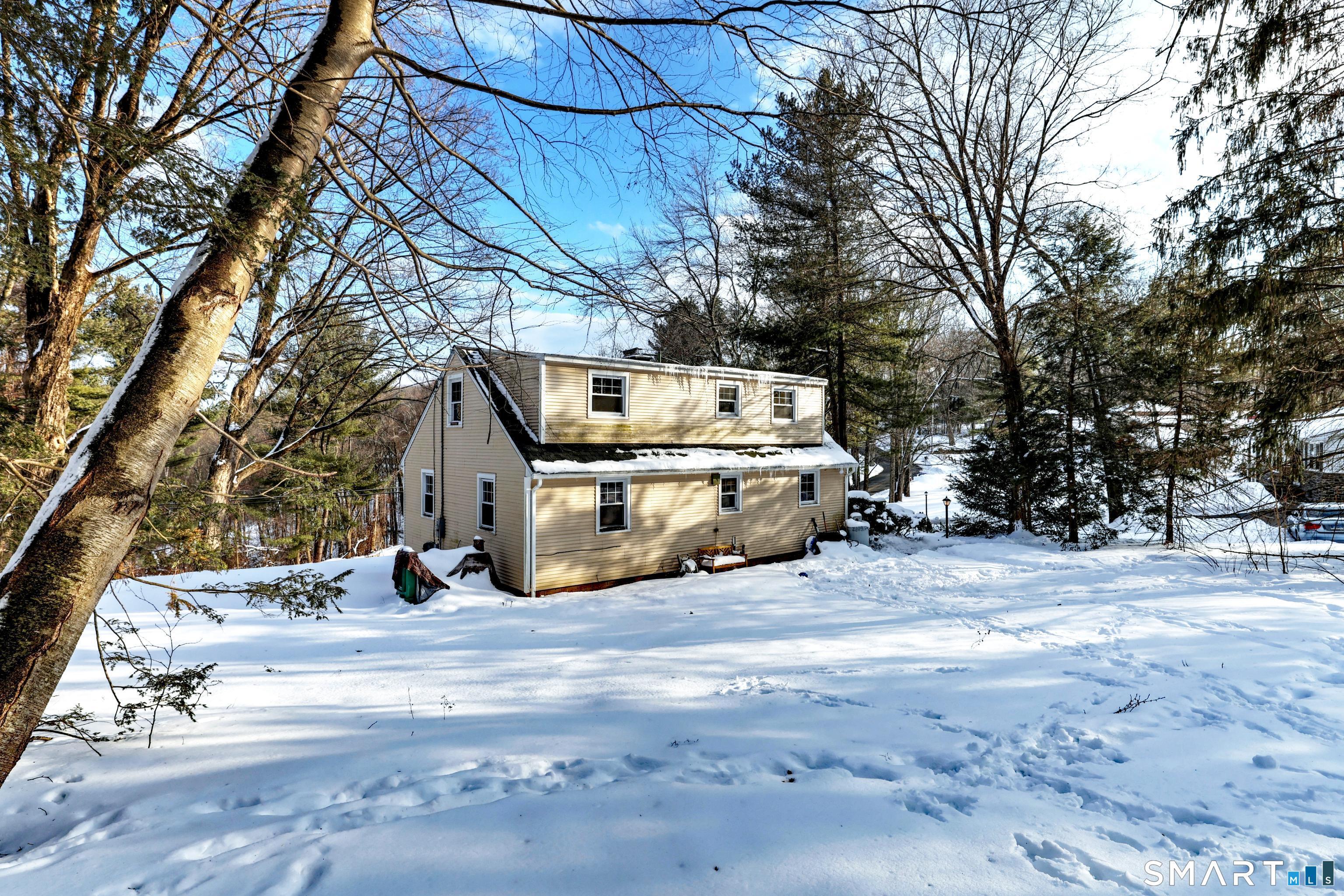 Image 2: The expanded layout offers extra living space while keeping that timeless Cape charm, all set against a peaceful, wooded backdrop.