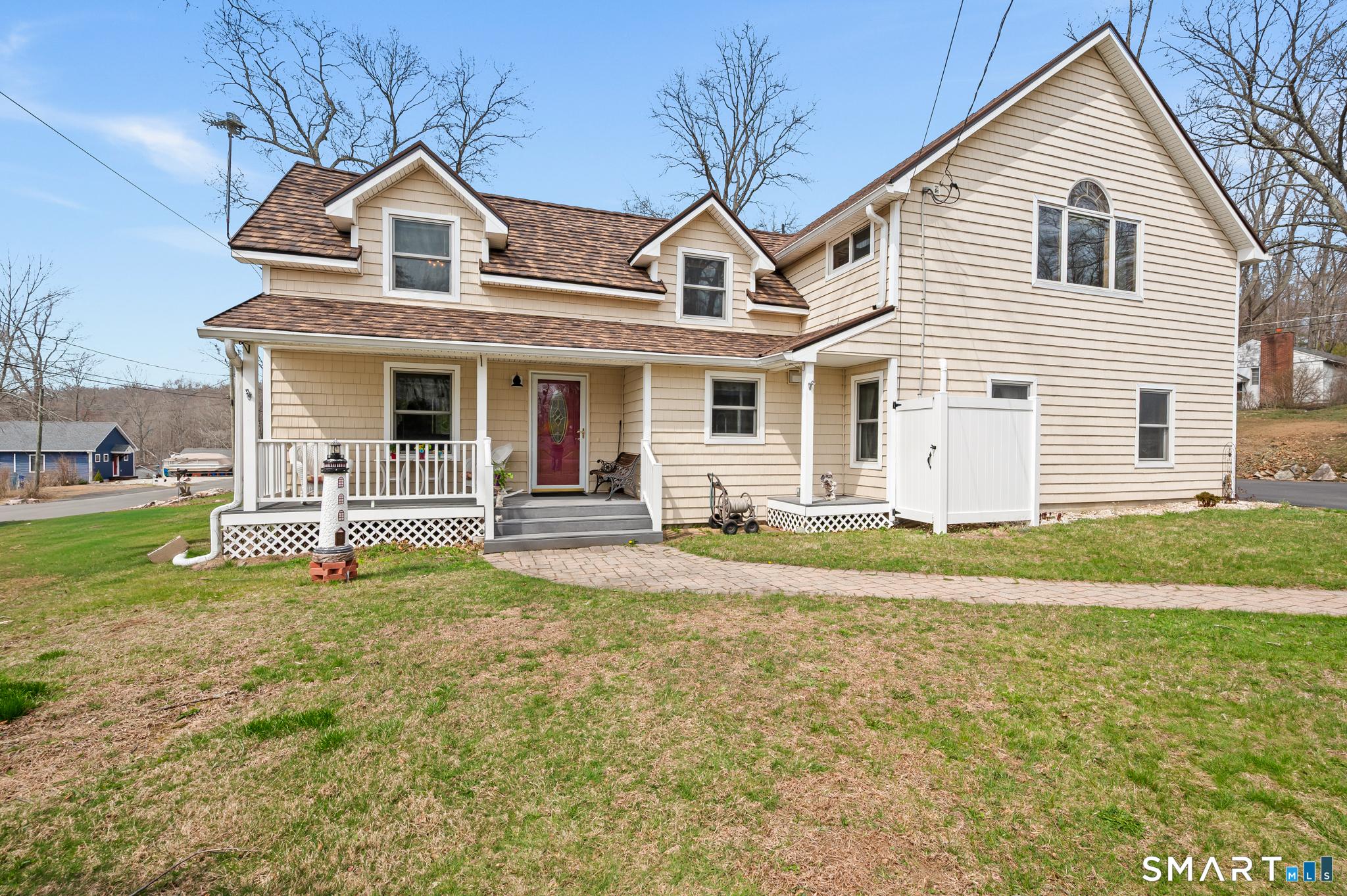 Image 2Front of House: This home has been remodeled with a 50 year metal roof, siding, windows, maintenance free deck, stone patio, updated bathroom and kitchen and so much more!