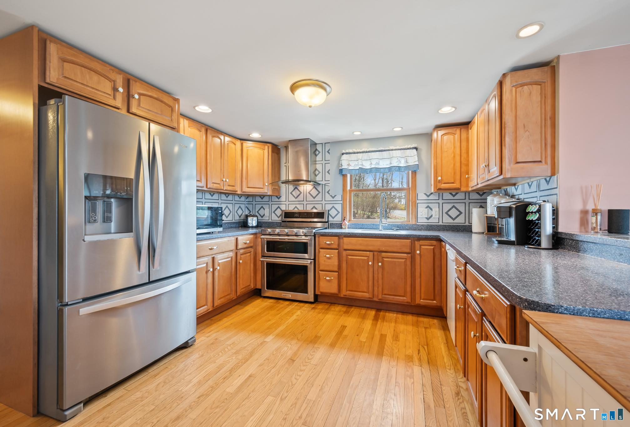 Image 4Kitchen: Remodeled kitchen with hardwood floors, and gas stove with hood, double oven, good amount counters for continuous work space and upper and lower cabinets!