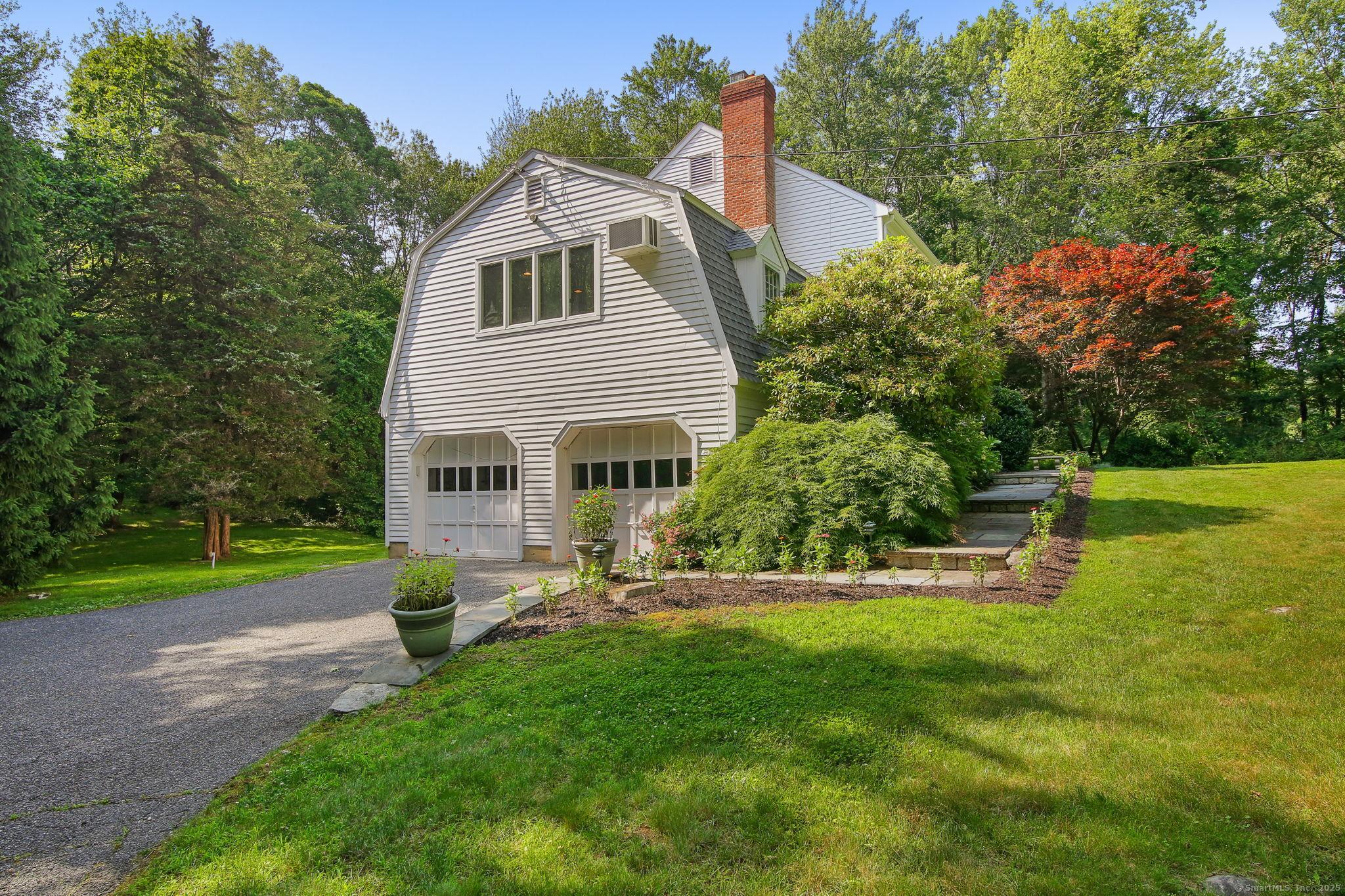 Image 4: Large driveway leads to two car garage