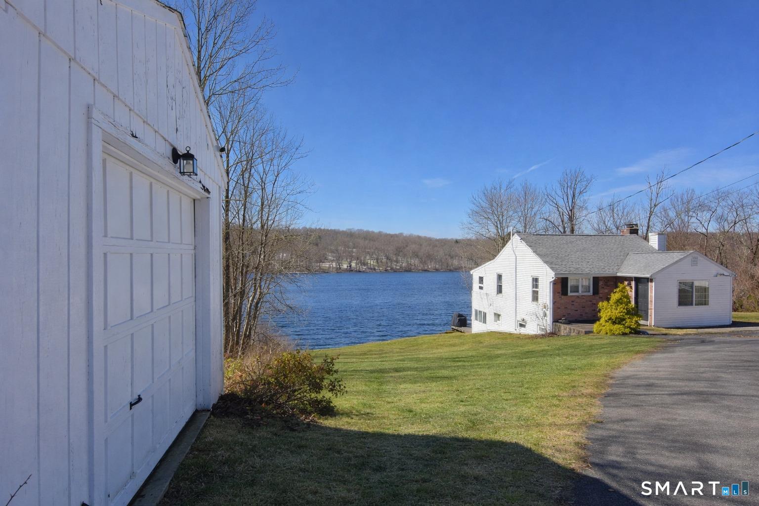 Image 1Front of Structure: The circular drive, waterfront shed, and one car garage add to the functionality of this property on coveted Quasset Lake.