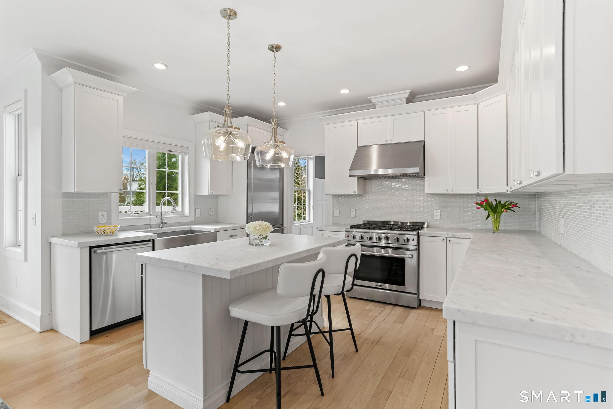 Image 4: Stunning Chef's kitchen! Marble countertops, custom cabinetry, high end stainless appliances & center island.