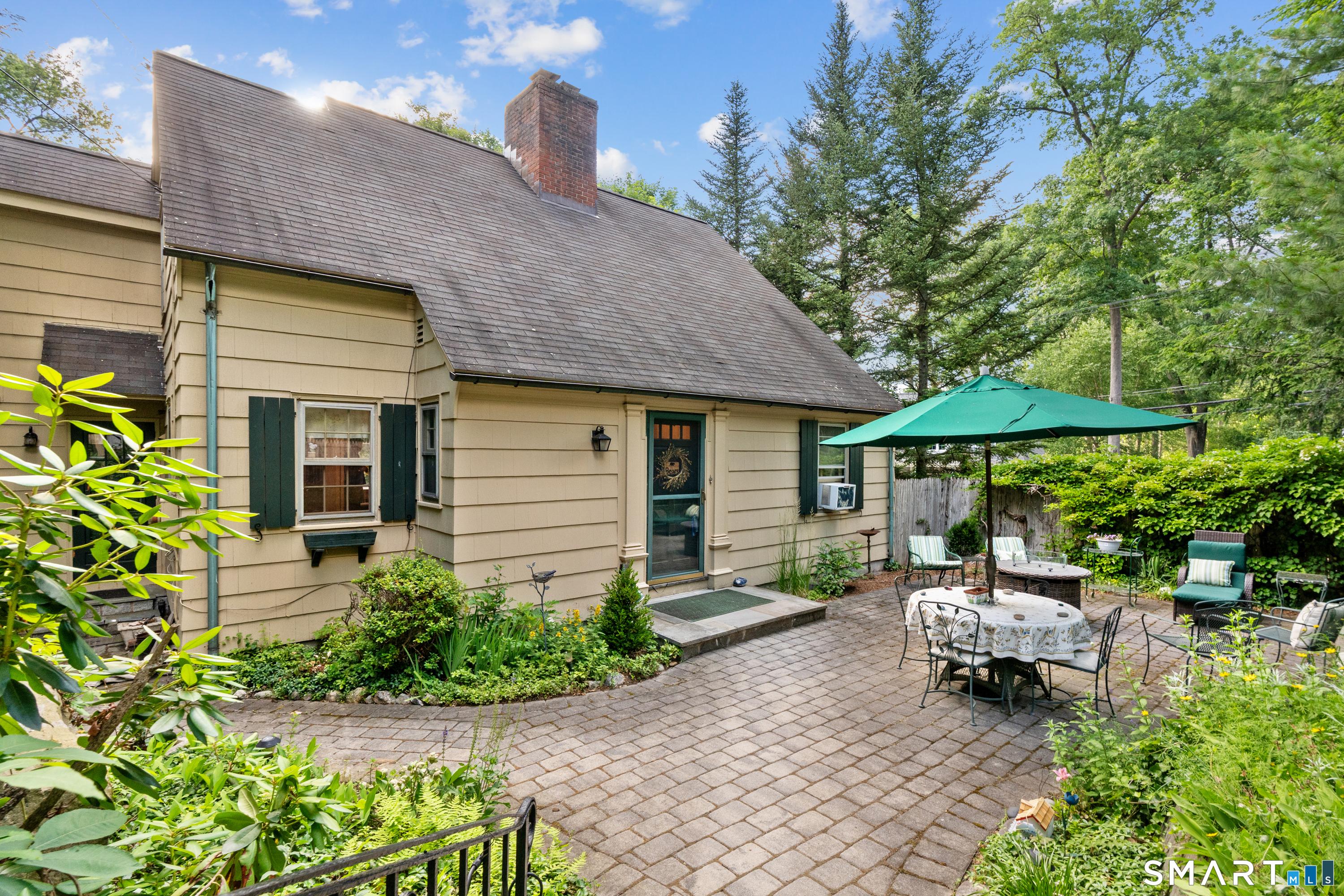 Image 2: The expansive front patio greets you and provides a lovely secluded spot to entertain and relax!