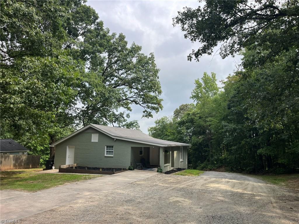Image 2: View of house and large parking area from top of driveway.