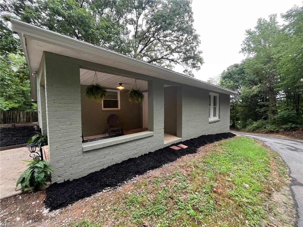Image 3: Welcome Home! Enjoy relaxing on the welcoming 10x12 covered porch oeverseeing a beautiful wooded scenery.