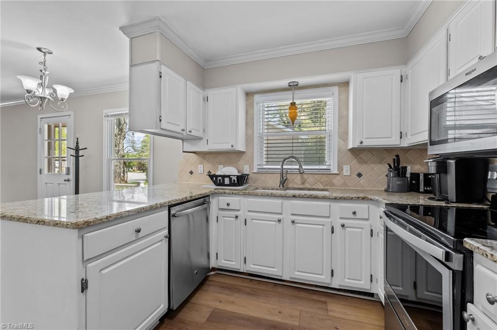 Image 2: Bright kitchen with granite countertops and abundant cabinetry