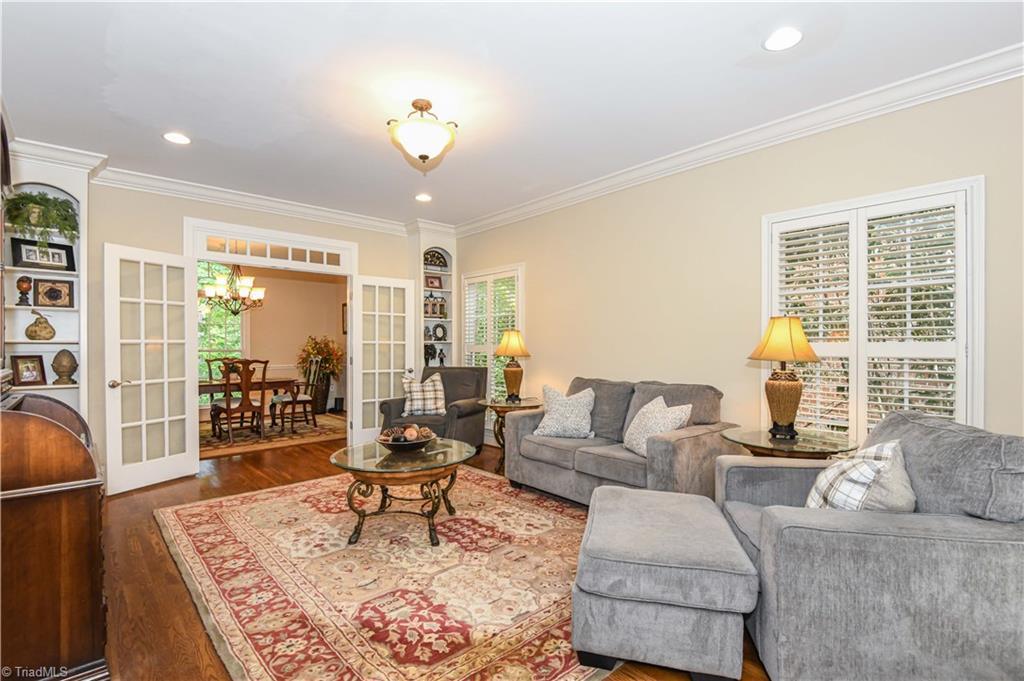 Image 4: Living area with built in book cases on both sides of the French door.