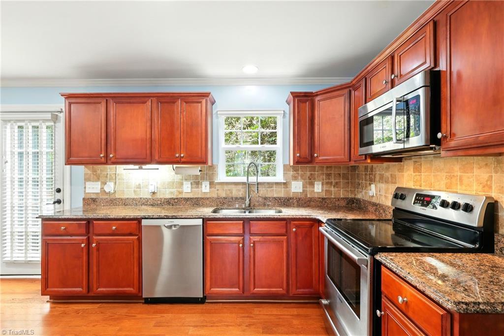 Image 4: A roomy kitchen featuring sleek stainless steel Bosch appliances, ample counter space, and a layout designed for both everyday living and entertaining.
