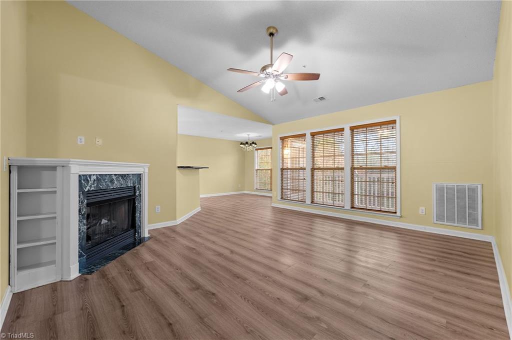 Image 3: Living room with an open floorplan, leading into the dining area.