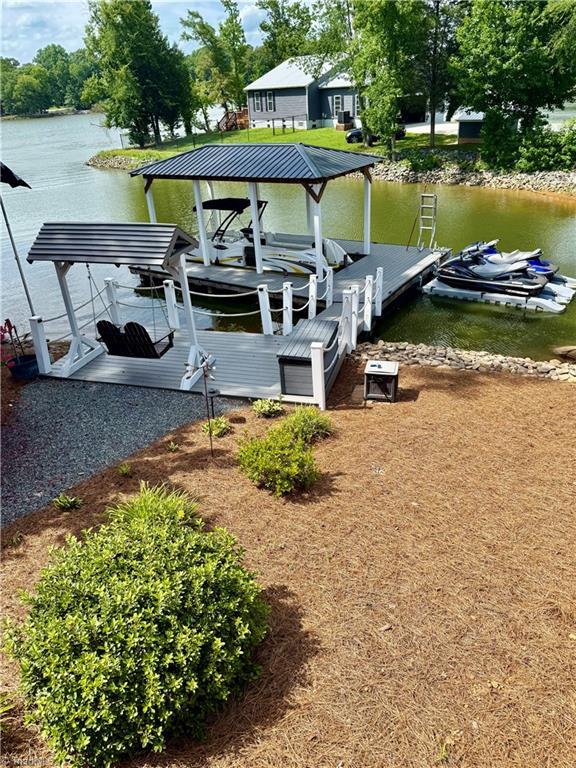 Image 4: Covered U-shaped composite floater dock with two jet ski floaters and  walk-in steps to enjoy quiet floating & swimming in cove plus a covered double swing to enjoy the view.