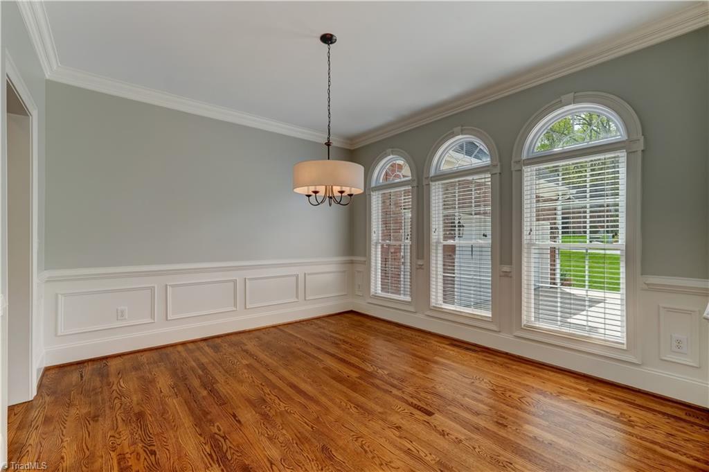 Image 4: Details abound in this lovely home with heavy crown molding, arched window details and wainscoting anchored by gleaming hardwood floors.