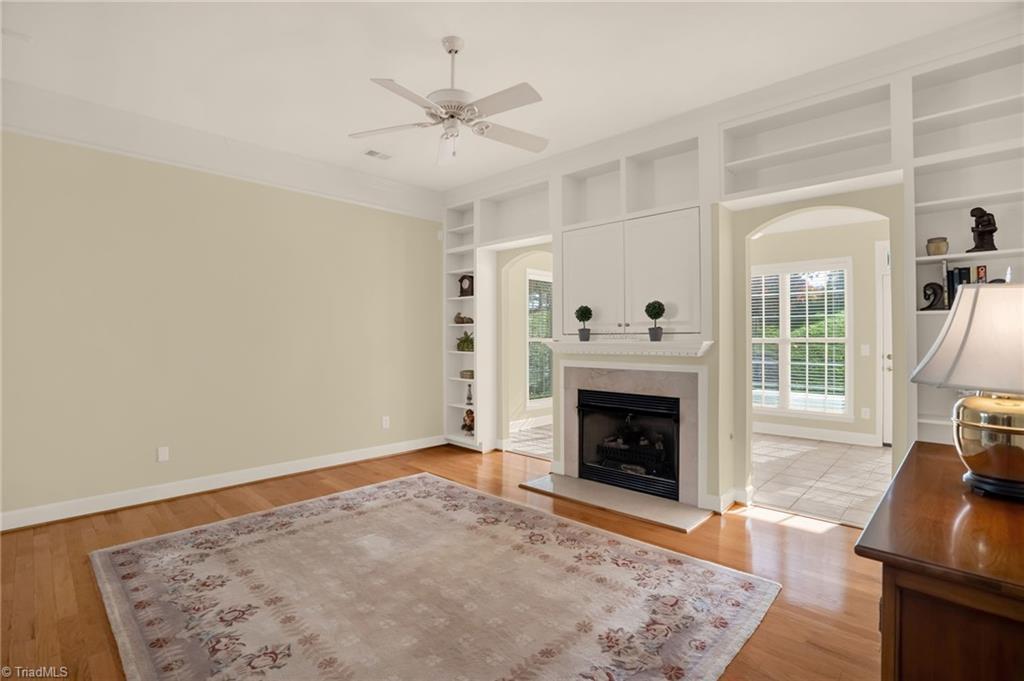 Image 2: Living room with gas log fireplace land built-ins. Living room opens to sunroom.