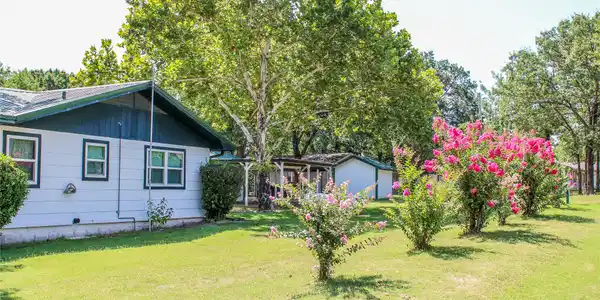 Image 2: White siding exterior with a dark green roof trim,