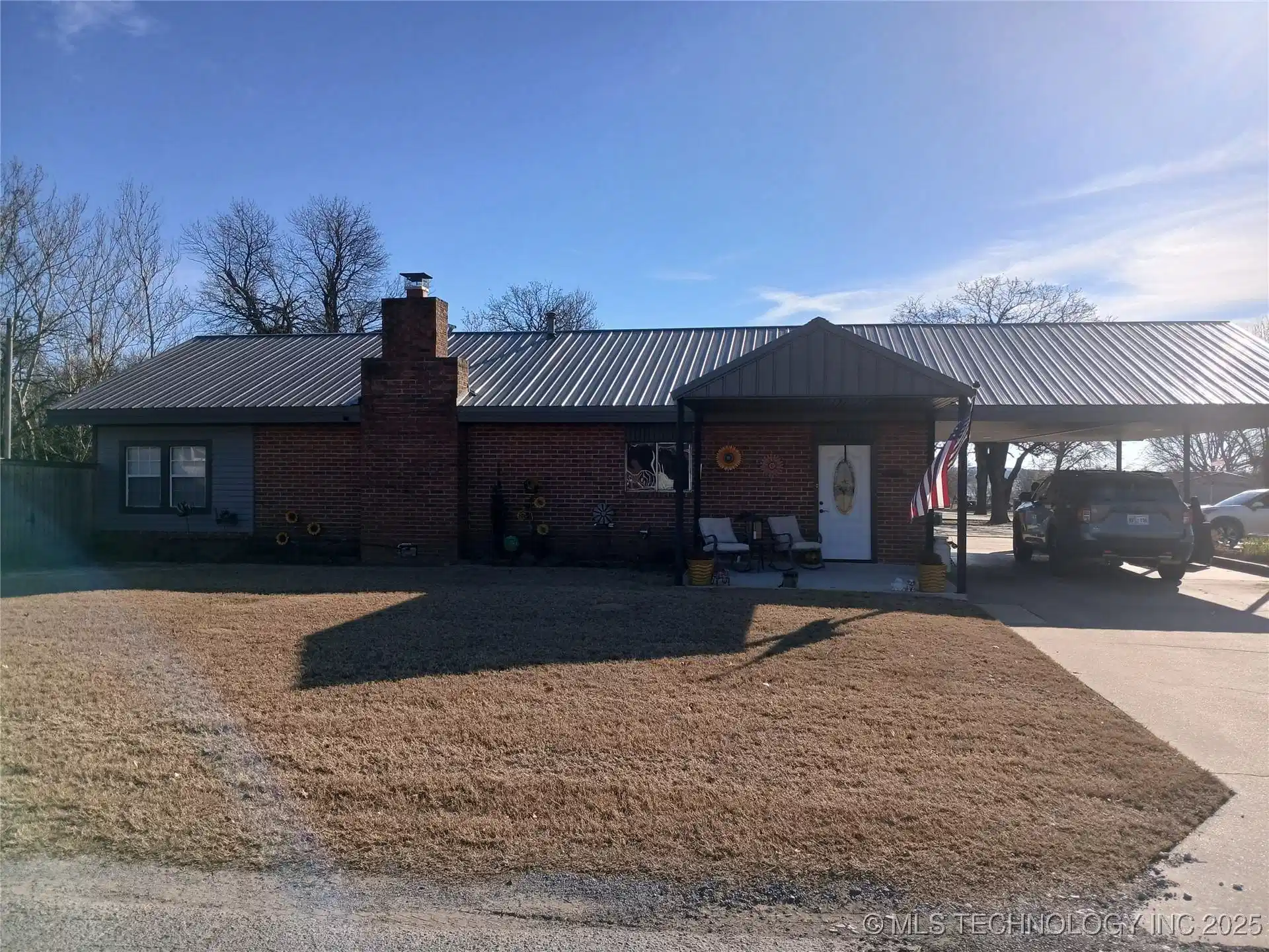 Image 1: Brick exterior with gray siding accents, prominent