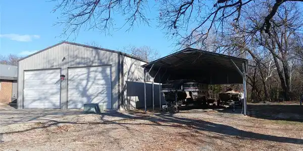 Image 2: Two-bay metal garage with roll-up doors and an att