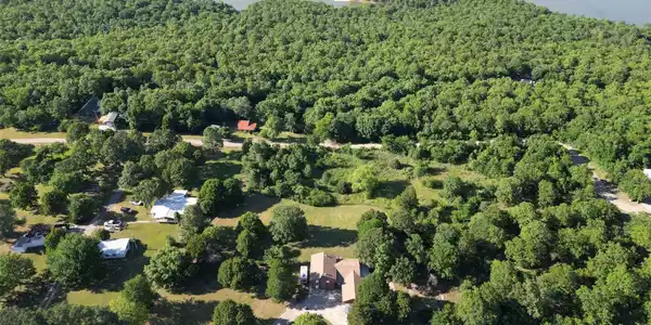 Image 2: Expansive property featuring verdant tree coverage