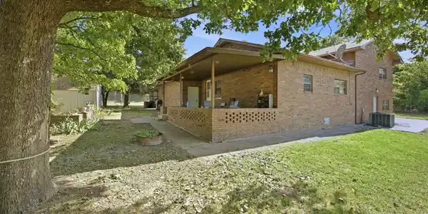 Image 3: Brick exterior featuring a covered patio, a verdan