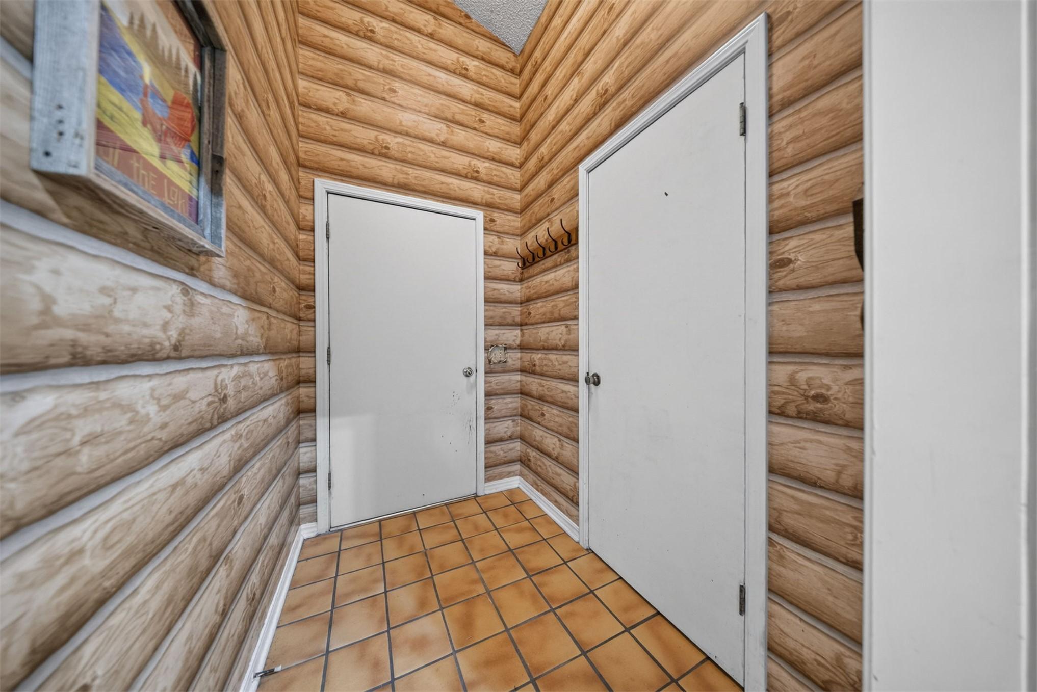 Image 4: Entryway featuring log-cabin style wood paneling,