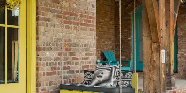 Image 3: Inviting porch swing on a concrete porch with bric