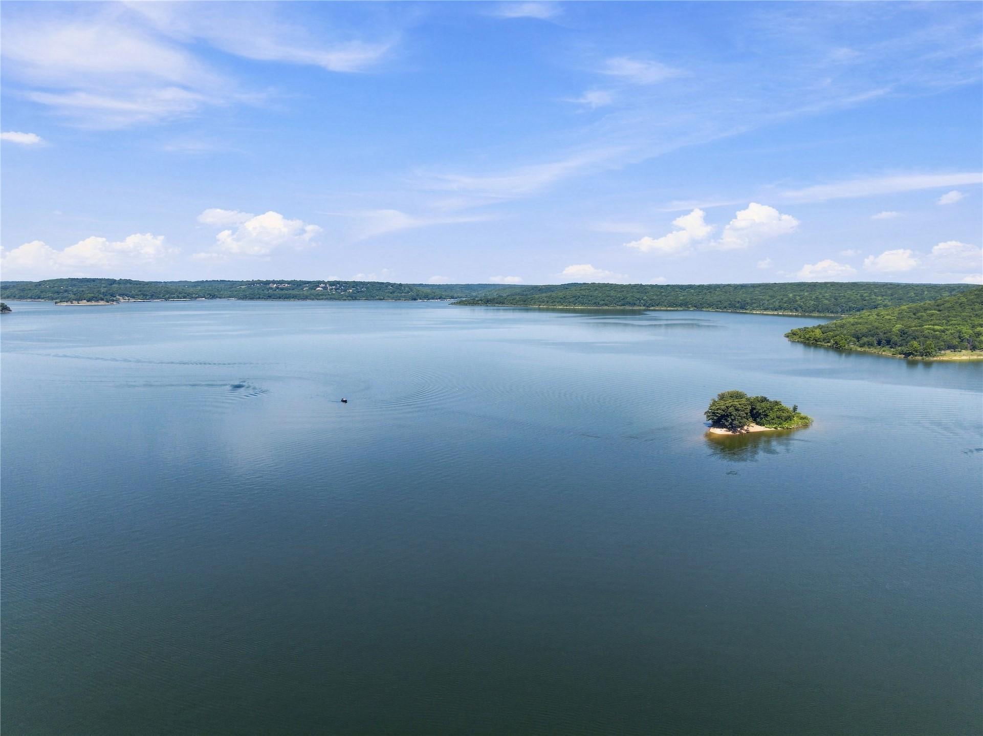Image 4: Expansive body of water with a small, tree-covered