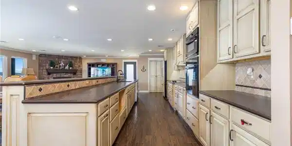 Image 3: Chef's kitchen featuring dual wall-mounted ovens,