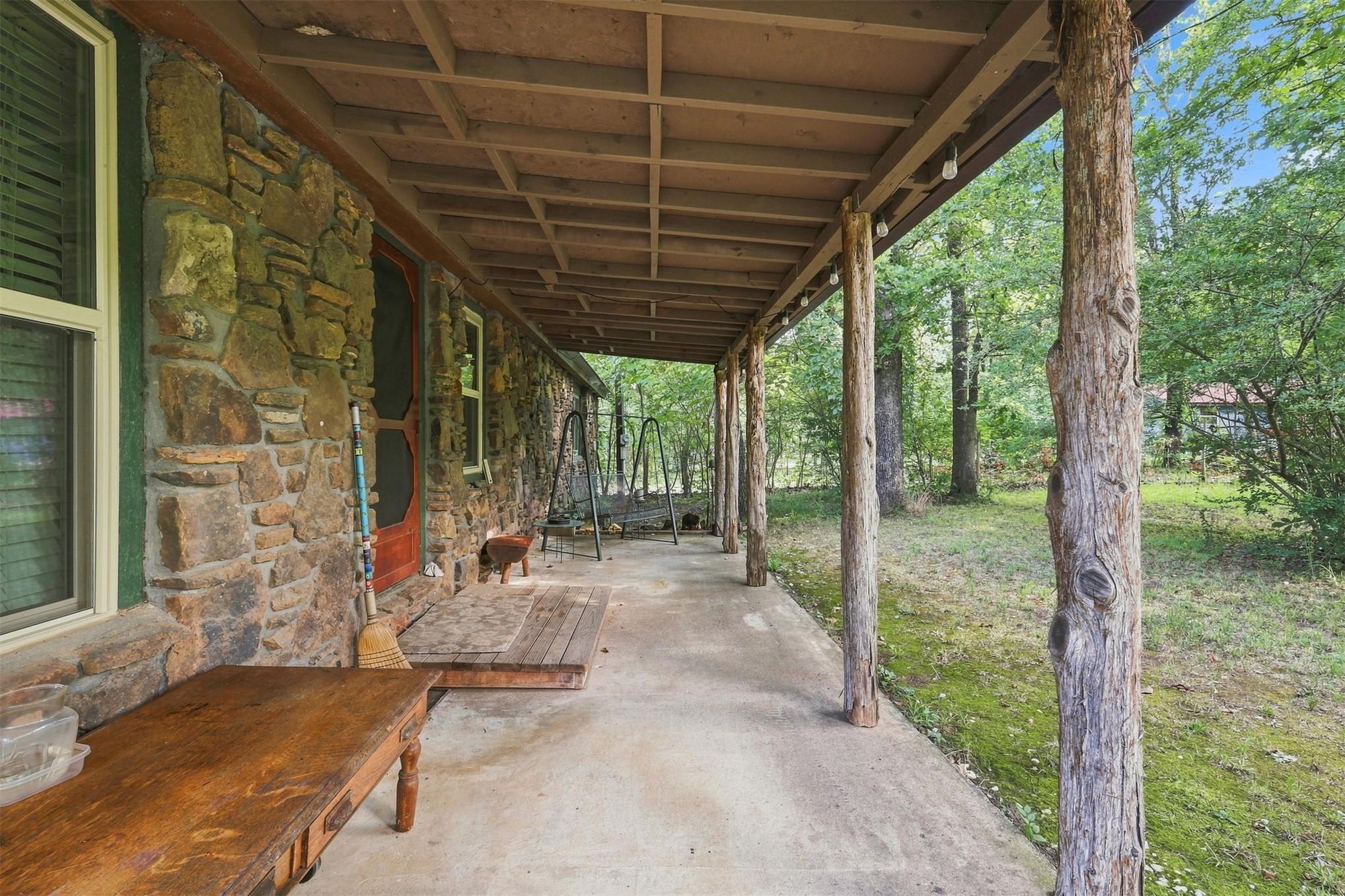 Image 3: Stone exterior featuring a covered porch with rust
