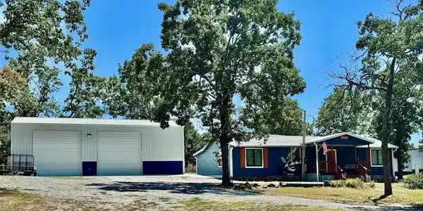 Image 2: Blue residential structure with a covered porch an