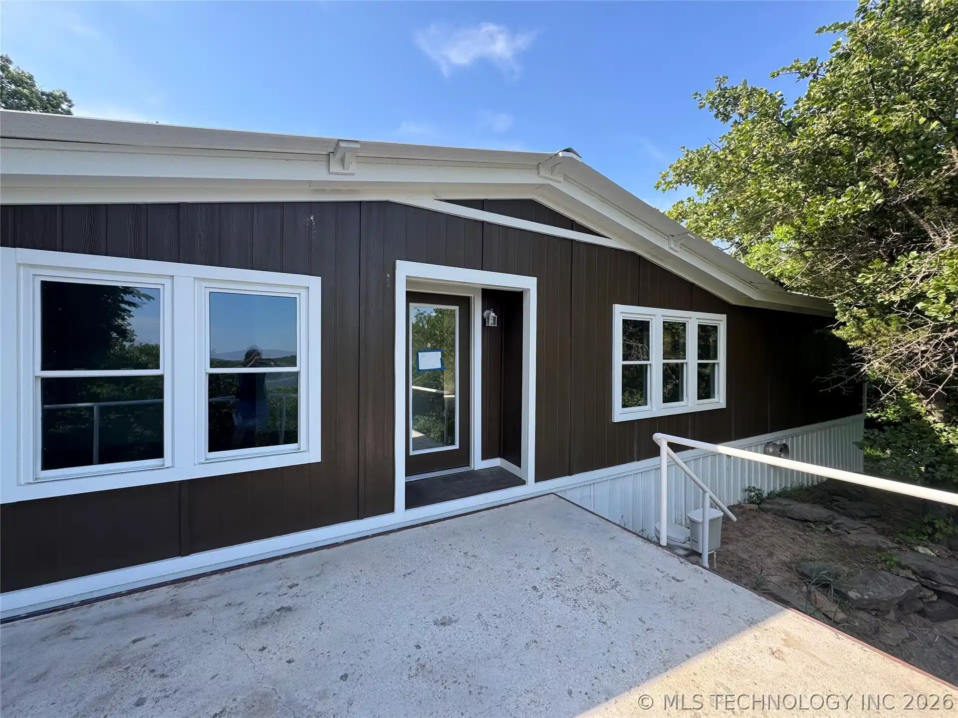 Image 1: Brown vertical siding exterior with white trim and