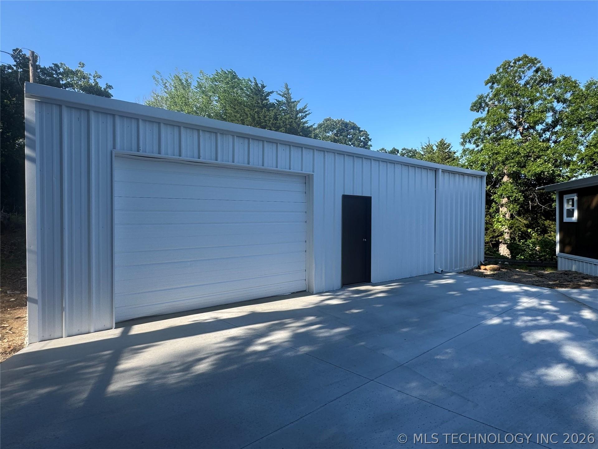 Image 4: Metal-sided outbuilding featuring a large roll-up