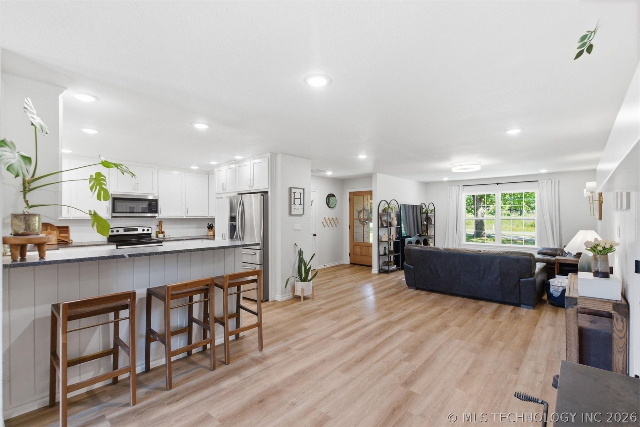 Image 2: Bright kitchen with white cabinetry, stainless ste