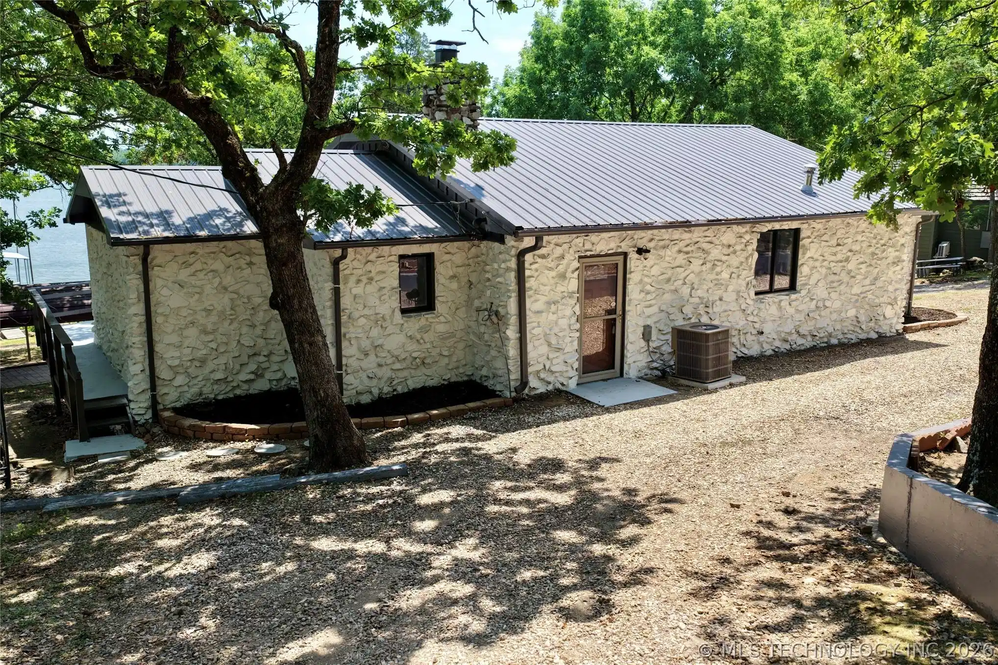 Image 1: Stone exterior residence featuring a metal roof, g
