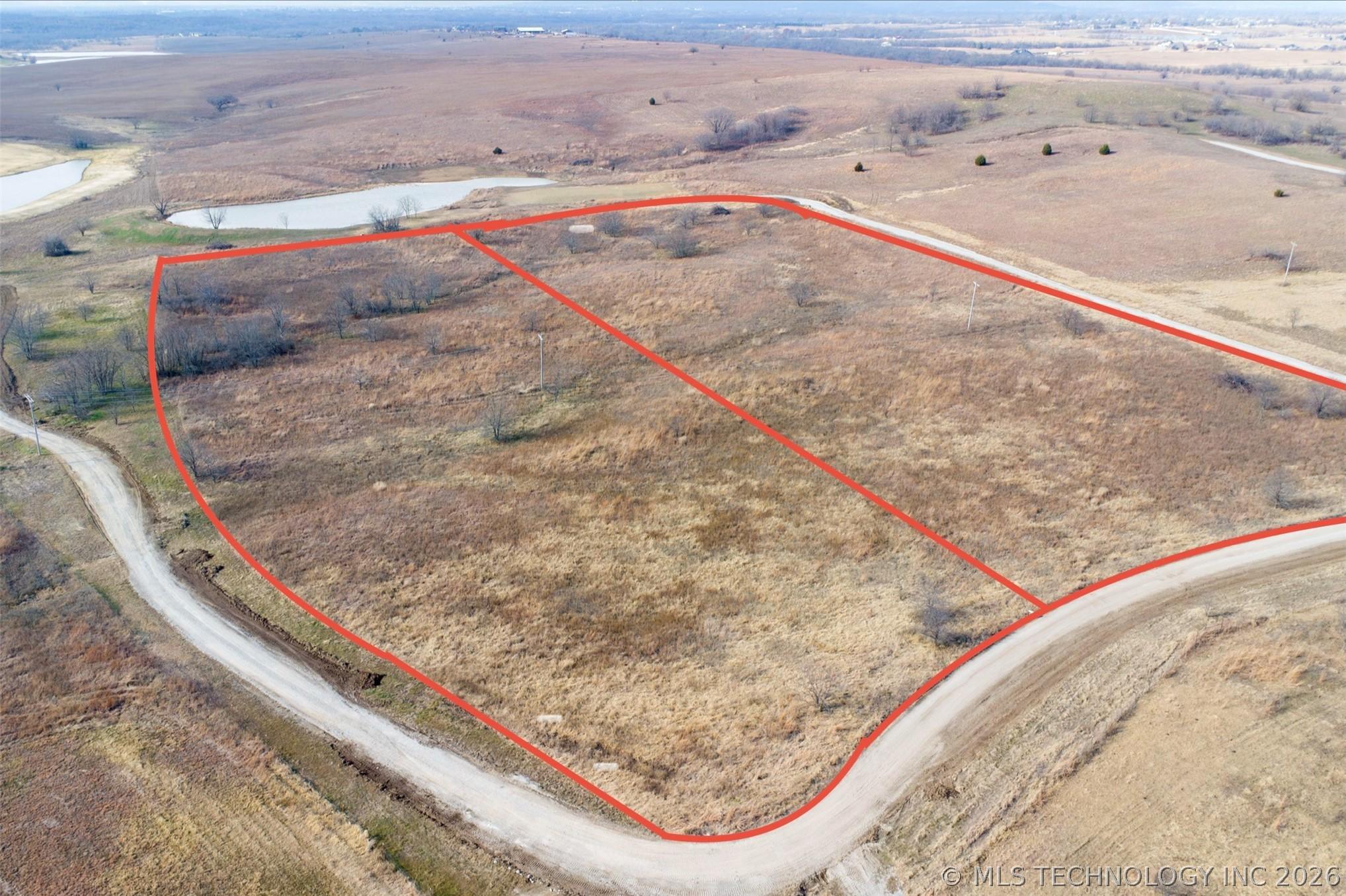 Image 2: Expansive undeveloped land featuring a gravel road